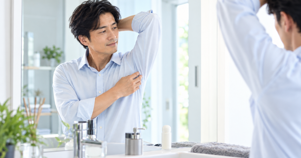 鏡の前でわきの身だしなみを確認する40代男性